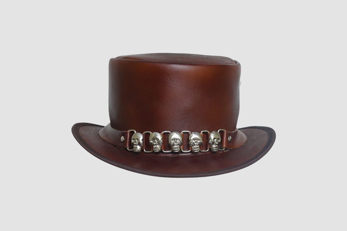 Brown leather top hat with five skull accents on the hatband
