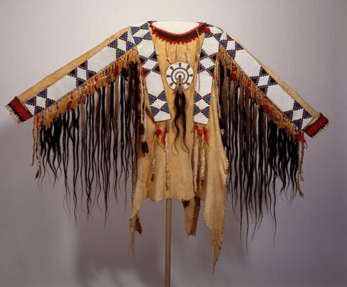 Women’s beaded suede war shirt with long dark hair trim and geometric beadwork