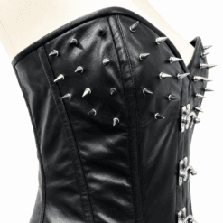 Close-up of the front upper panel on a women's black spiked leather corset with silver cone spikes and steel busk closure